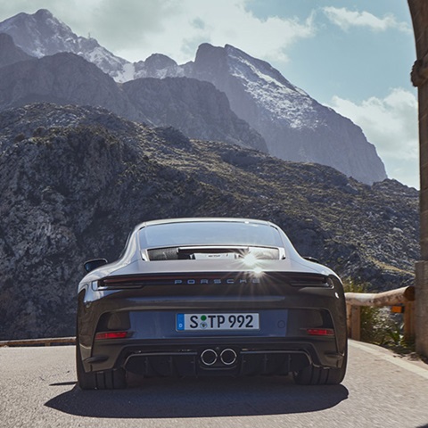 911 GT3 with Touring Package under bridge, mountains ahead