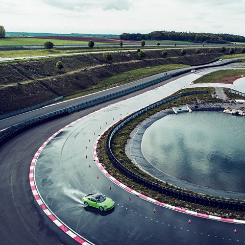Green porsche is driving on the track