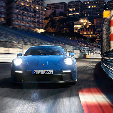 Blue 911 GT3 straddles kerb at Monaco at night
