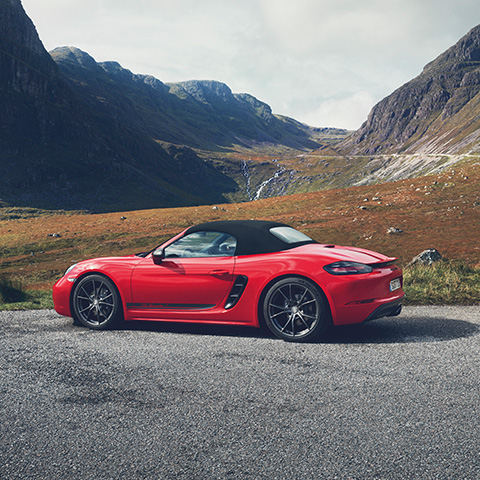 Red Porsche 718 Boxster T parked up in Scottish mountains
