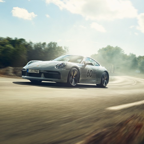 Grey Porsche 911 Sport Classic driving through a sunlit corner