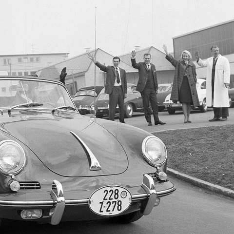 Black and white photo of Porsche leaving factory in early 1960s