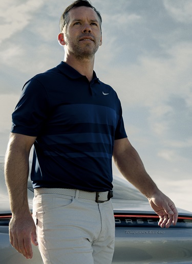 Paul Casey is standing in front of clouds while he looks up into the sky. We see him frontal from a low angle.