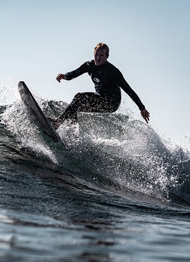 Close-up of a man in a wetsuit surfing a wave