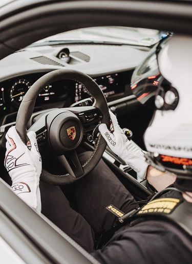 A racing driver sitting in a Porsche