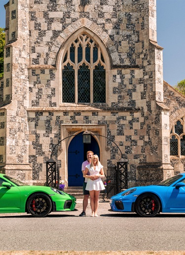 Green and blue 718 Cayman GT4, couple standing in between